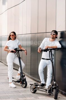 A couple on electric scooters ride around the city, a couple in love on scooters / Photodune, Misc