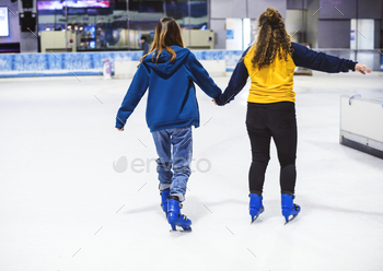 Girl friends ice skating on the ice rink together / Photodune, Misc