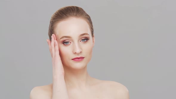 Studio portrait of young, beautiful and natural woman over grey background.