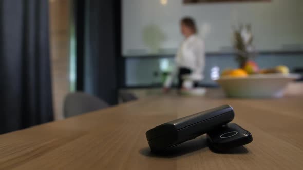 Female Hand Taking Car Key From Kitchen Table