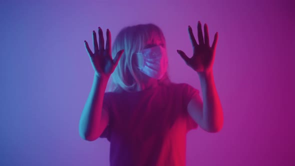 Woman in Medical Mask Emerges From Smoke and Touches Glass with Palms