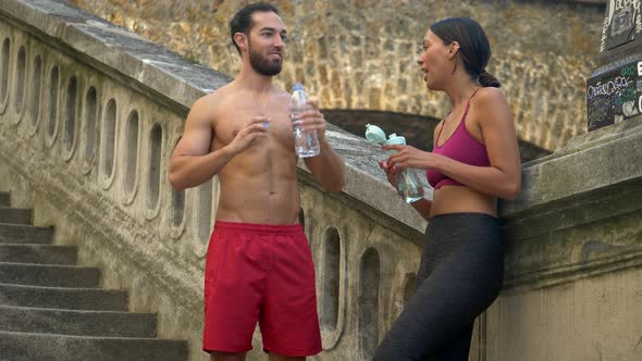 A couple take a break after a workout to drink water