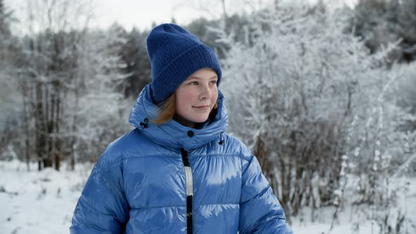 Cute Smiling Girl Walking in Snowy Winter Park