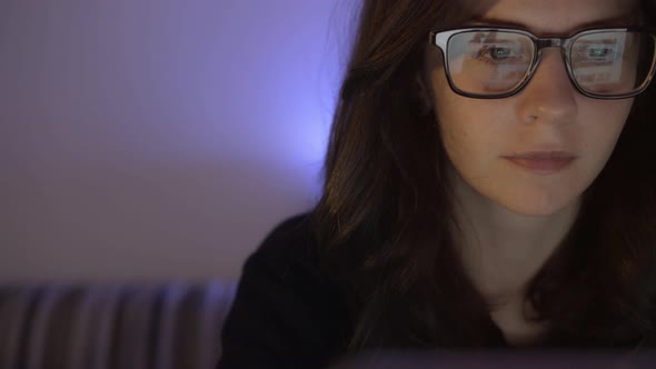 Pan Shot of Female Face Sitting in Front of the Computer in Eyeglasses