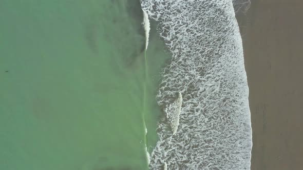 Aerial view, top down of the Pacific ocean with a green coloration