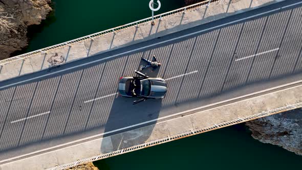 A car passes through a bridge over a river aerial view 4 K