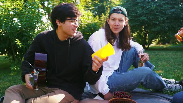 Company of Beautiful Young People and Dog Having an Outdoor Lunch