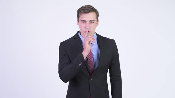 Young Happy Handsome Businessman with Finger on Lips