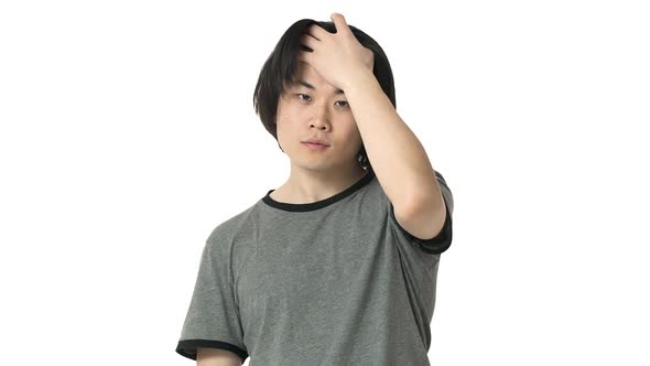 Portrait of Handsome Asian Man Wearing Casual Gray Tshirt Looking on Camera and Touching His