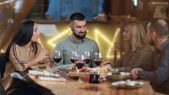 Group of Young Man and Woman Enjoying Double Date at Restaurant