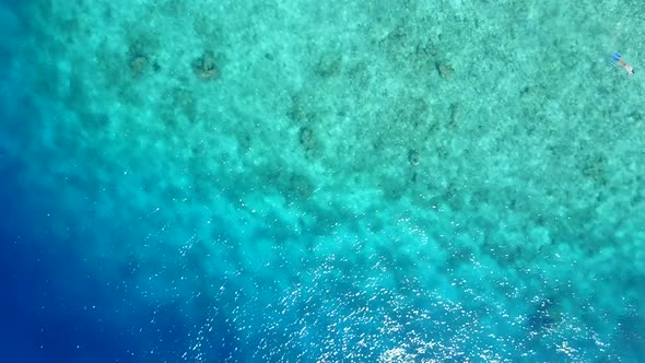 Aerial drone sky of resort beach by blue lagoon with sand background