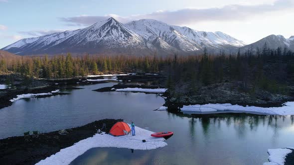 Camera Turning Around a Camping with Hiker and His Dog in Mountains. Aerial