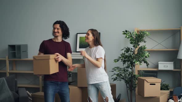 Man and Woman Bringing Boxes with Personal Things Moving in To New House