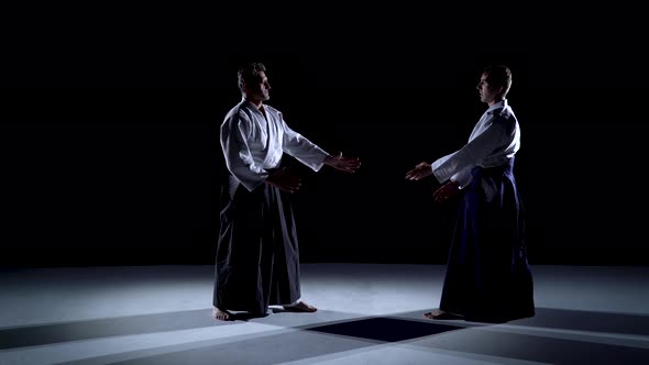 Two Masters Participants of the Training in Special Clothes of Aikido Hakama Work Out the Methods