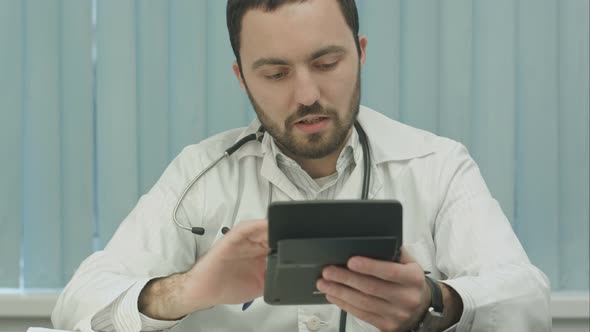Young  Male Doctor with a Calculator Make Calculations and Make Notes