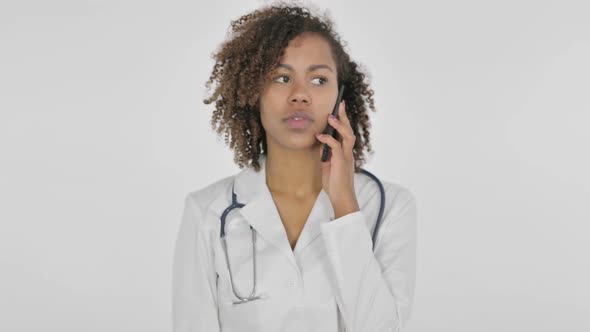 African Female Doctor Talking on Phone on White Background