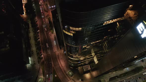 High Angle Rising Footage of Tall Modern Skyscraper and Traffic on Surrounding Streets
