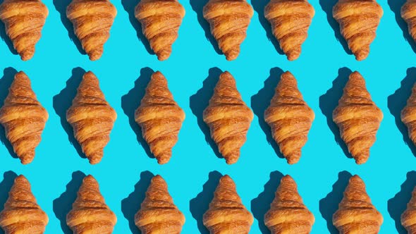 Flat Lay of Croissants Motion Pattern on a Color Background