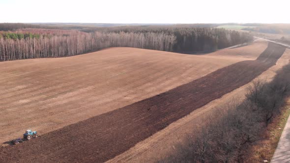 Tractor on nature harvest field. Agricultural cultivation for production organic food.