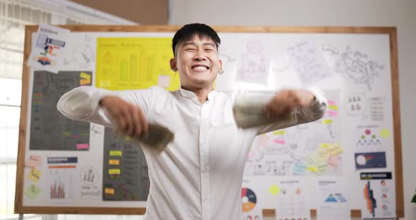 Successful asian businessman throwing banknotes