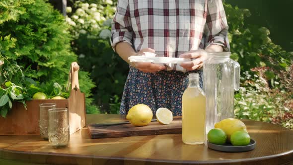 Woman Making Summer Lemonade Cocktail in Backyard Garden