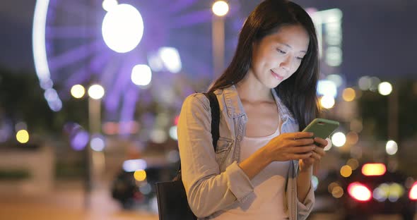 Woman using mobile phone at night 