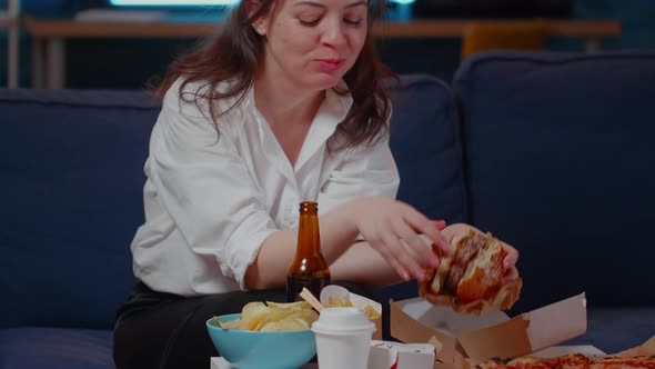 Young Person with Fast Food Meal Watching Television