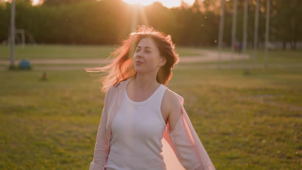 Smiling Lady in Unbuttoned Shirt Shakes Loose Hair on Field