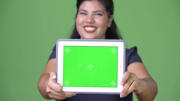 Young Overweight Beautiful Indian Businesswoman Against Green Background