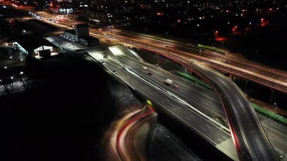 Drone shot of night traffic on a motorway showing cars and lanes of light with Tunnel and viaducts o