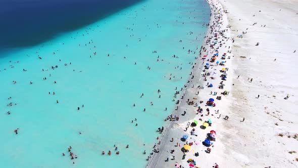 People Swim on Vacation in the White Sandy Beach of the Clear Tropical Turquoise Light Blue Sea
