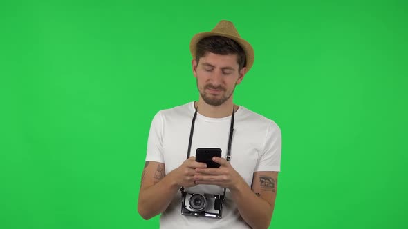 Portrait of Confident Guy Is Texting on His Phone. Green Screen