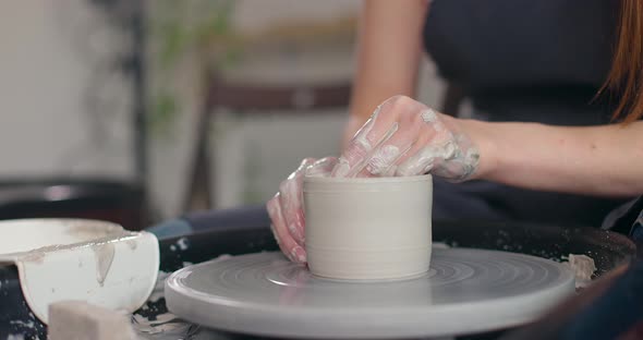 Closeup of Young Woman's Hands in Pottery Studio Using Pottery Wheel Handmade Ceramics Creative