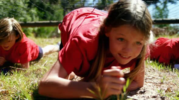 Kids crawling under the net during obstacle course training