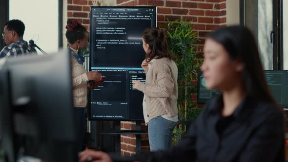 System Engineers Comparing Source Code on Wall Screen Tv Analyzing Errors Using Digital Tablet