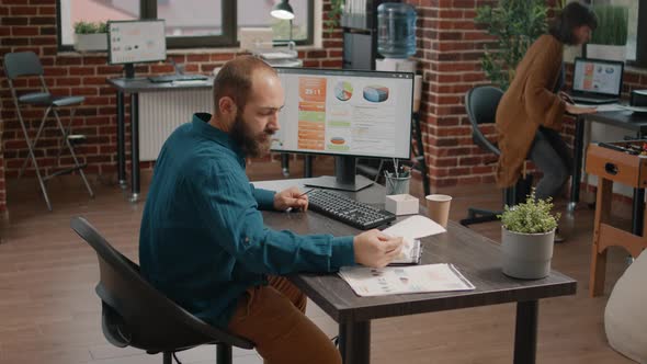 Entrepreneur Looking at Papers and Computer with Rate Charts