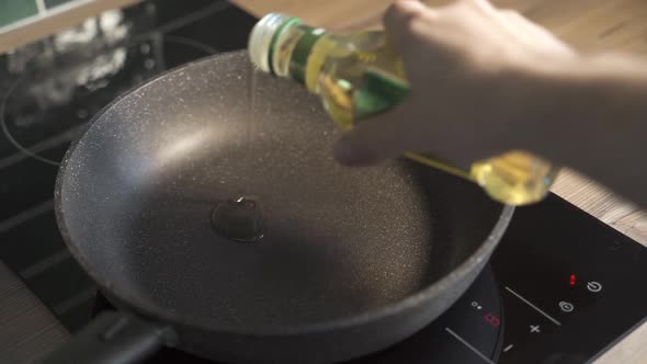 Man Pouring Cooking Oil on the Frying Pan