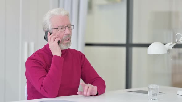 Old Man Talking on Smartphone at Work