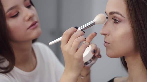 Makeup Artist Doing Makeup for Brunette Client in Salon