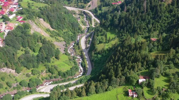 aerial top down view of a curved mountain road near a village in Uzungol Trabzon Turkey on a sunny s