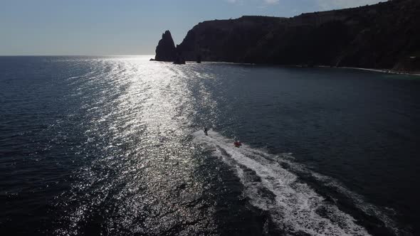 Happy People Swim on Air Mattress Behind a High Speed Water Bike