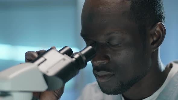Black Scientist Using Microscope in Lab