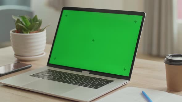 Laptop With Green Mock-Up Screen On The Table