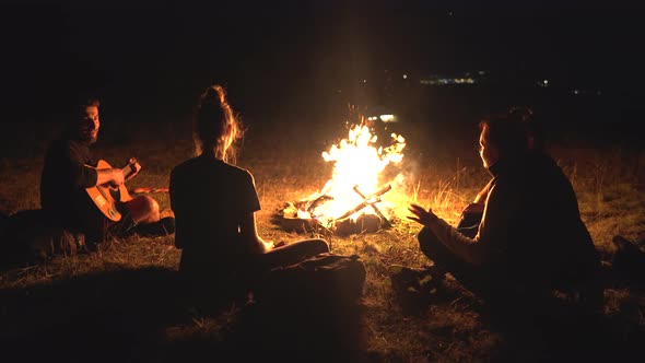 Friends sitting around a campfire