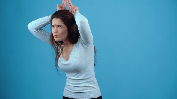 The Angry Young Brunette Shows Her Horns and Looks Sullenly Around