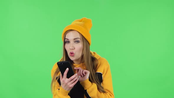Portrait of Modern Girl in Yellow Hat Is Asking for Information on the Network Via Phone
