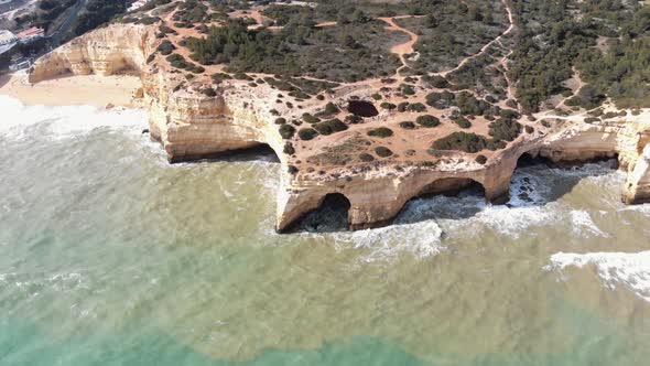 Drone footage of the unique cliffs and rock formations along the shoreline near the coat of Benagil