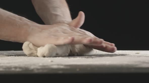 Male Hands Divide Baking Dough Into Shares on a Board Sprinkled with Flour