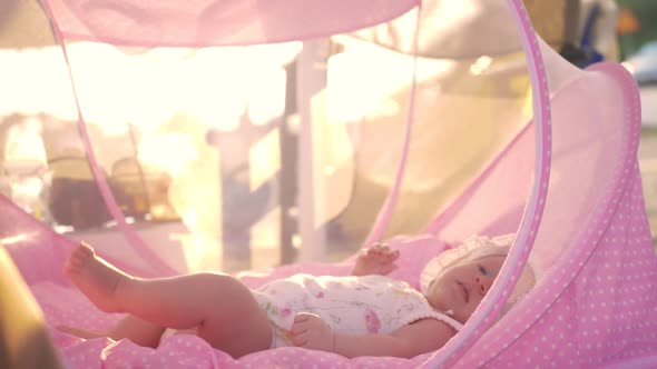 Baby Lying in Pink Bassinet Outdoor