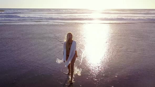 Attractive Blond Woman Walking on the Beach